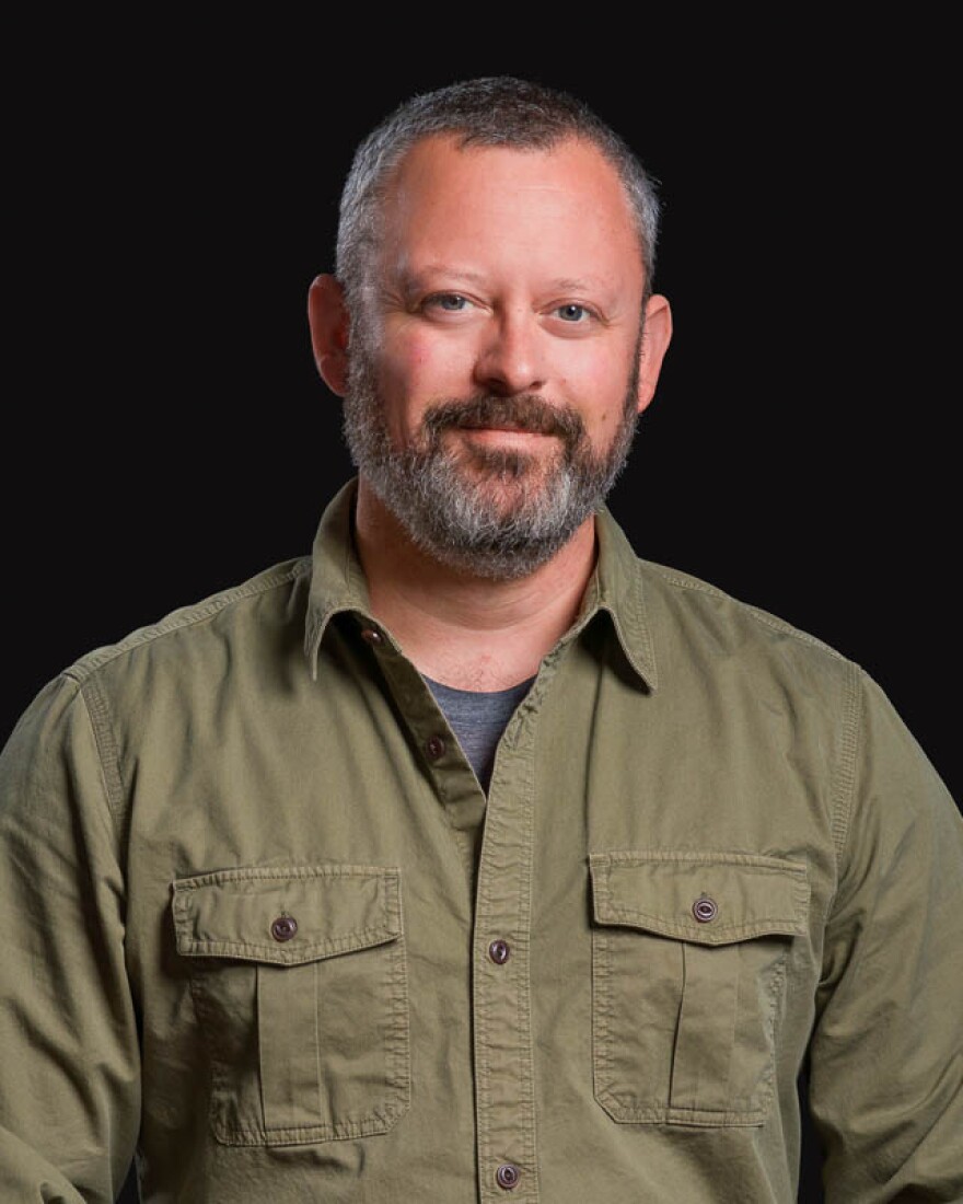 A man in front of a black background.