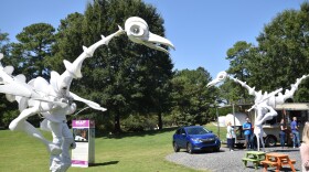 "Birdmen" roam through picnic tables in Ballantyne's Backyard at the 2023 Charlotte International Arts Festival.