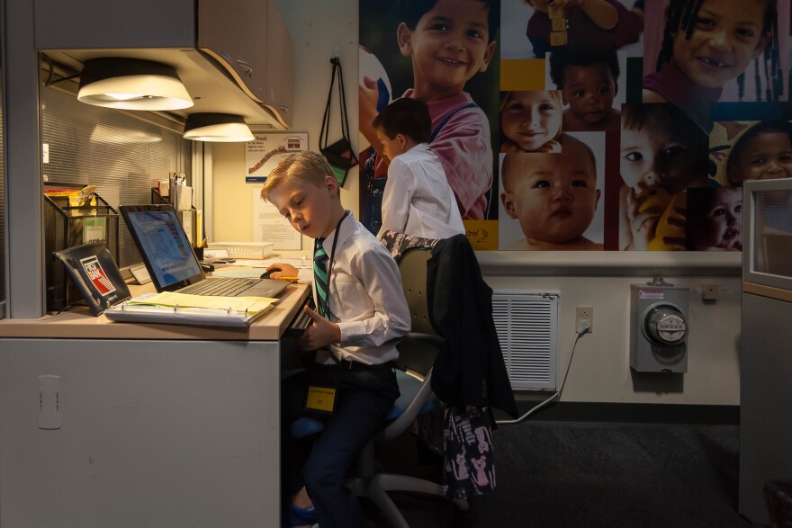 In shirts and ties, boys go over the books of the hospital in the fictional JA BizTown. Running the city is part of a weeklong summer camp on business and entrepreneurship.