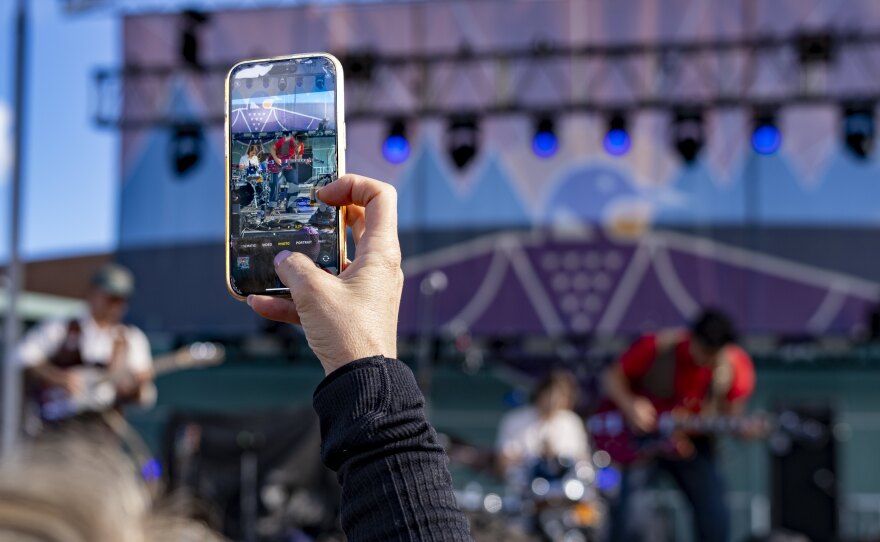 An audience member captures part of Jeremie Albino's set during Grand Rapids Riverfest on Sept. 6, 2025.