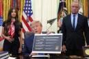 President Donald Trump speaks as Health and Human Services Secretary Robert F. Kennedy Jr., right, and Jayme Franklin listen during a meeting to sign an executive order about vaccines in the Oval Office of the White House in Washington.
