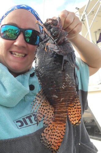 Captain Cindy Garb poses with a lionfish captured during a spearfishing dive on June 21, 2022, off the coast of North Carolina.