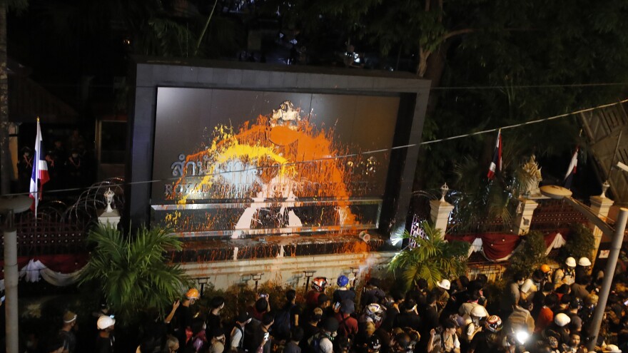 Pro-democracy protesters splash colored paint on the police headquarters sign in Bangkok, Thailand, on Wednesday.