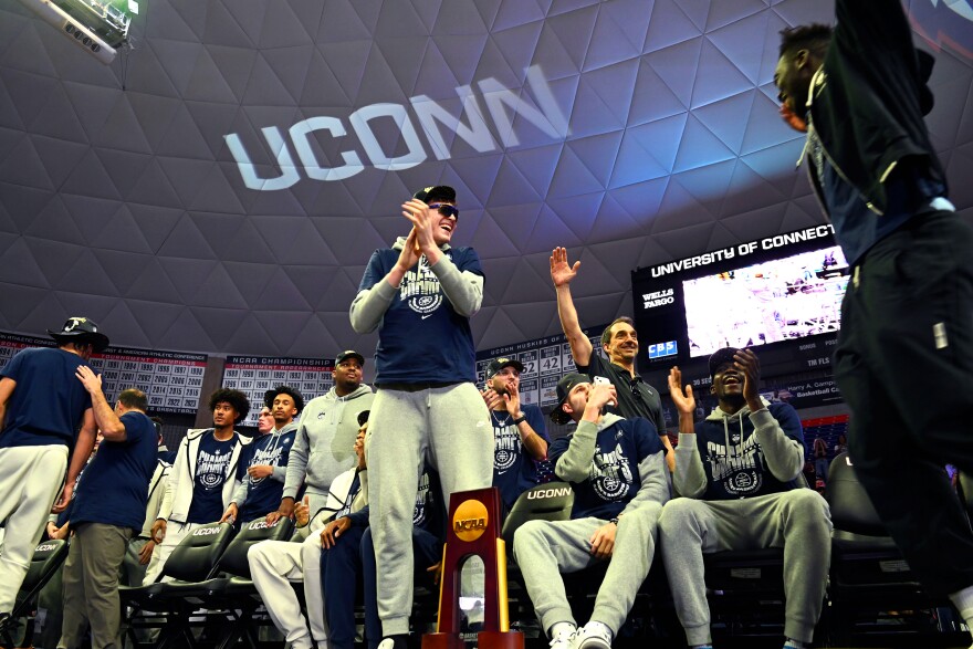 Freshman center Donovan Clingan cheers on teammate Adama Sanogo (junior, forward) as he enters the stage at Gampel Pavilion after winning the NCAA championship in Houston, Tx.