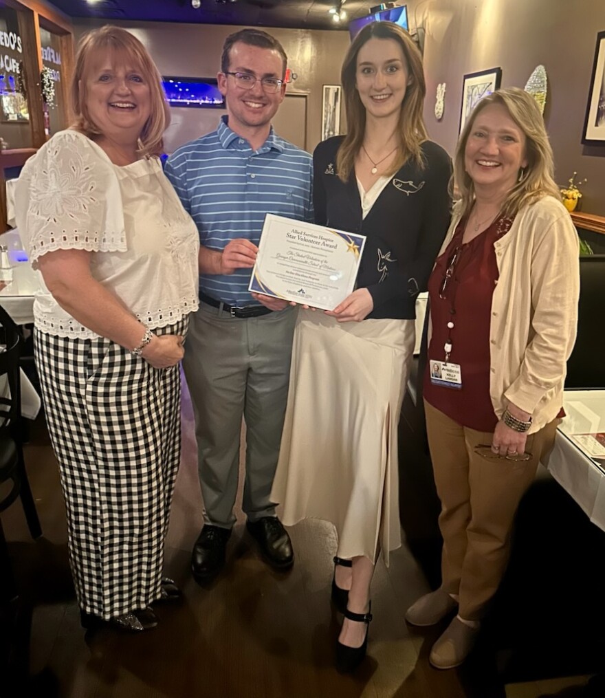 Allied's volunteer coordinator Laurie Fleming (left) awards members of the No One Dies Alone program Allied Hospice's star volunteer award.