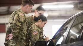 Guard members at a car