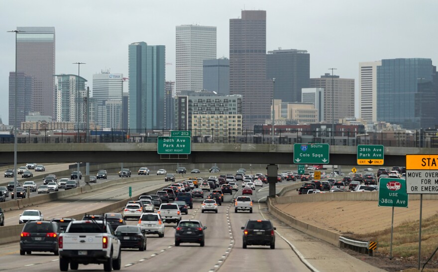 Lines of traffic head to a large skyline.