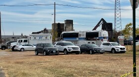 ATF vehicles parked at the warehouse fire scene, in front of an excavator moving debris