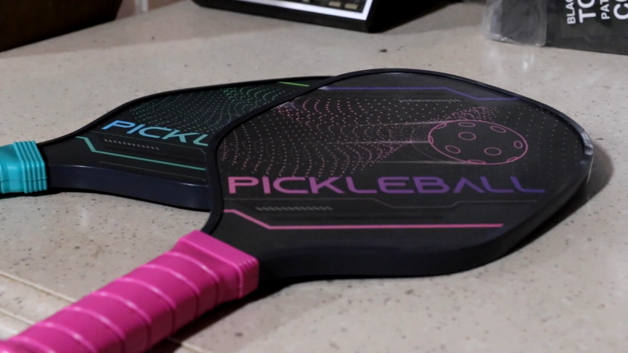 Pickleball players use paddles to hit the pickleball over the net.