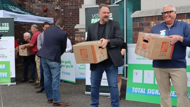 Let's Go Washington founder Brian Heywood (center) helps turn in boxes of signatures supporting I-2066, the initiative focused on protecting natural gas access, at the Secretary of State's Tumwater office Tuesday, July 2, 2024.