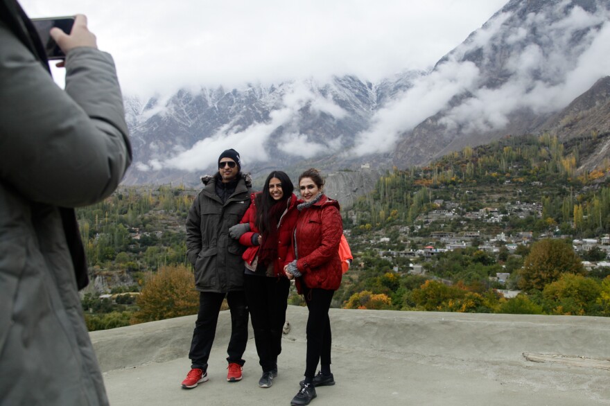 Tourists pose for photos on a medieval fort near the town of Karimabad in the highlands of Pakistan.