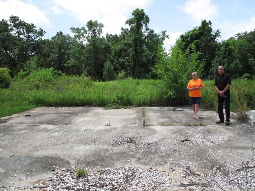 Stephanie Nelson Bosarge and her brother Paul Nelson show what's left of the family's oyster processing shop. The raised concrete slab is what's left of the oyster run.