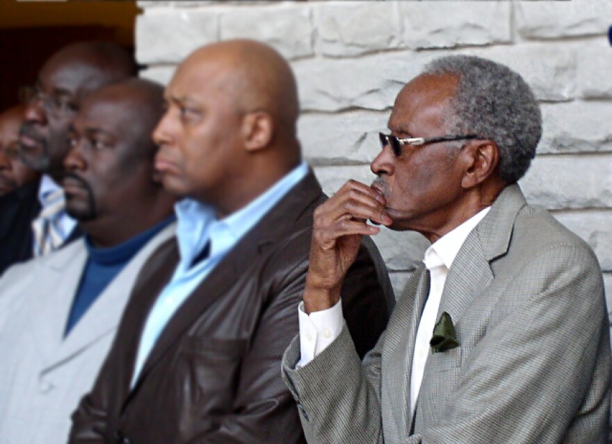Former mayoral candidate Alvin Brooks listens as the Reverend Wallace Hartzfield says the firing of the city manager was Handled in a \"wrong and immoral\" way.