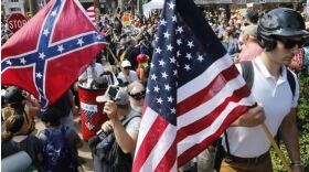 A large group of protesters holding U.S. and Confederate flags.