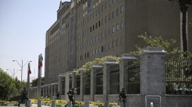 Police officers run to take position around Iran's parliament building after an assault of several attackers, in Tehran, Iran, Wednesday, June 7, 2017. Several attackers stormed into Iran's parliament and a suicide bomber targeted the shrine of Ayatollah Ruhollah Khomeini on Wednesday, killing a security guard and wounding 12 other people in rare twin attacks, with the shooting at the legislature still underway. (Fars News Agency, Ali Khara via AP)