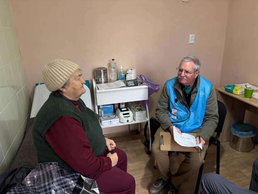 Colorado physician assistant Bob Downs, right, treating a patient in rural Ukraine in December.