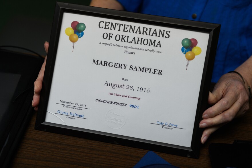 Gloria Helmuth displays an example of the plaque that the group presents to those who are 100 or older. In Oklahoma, there are thought to be about 500 people alive today who are 100 or older.