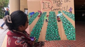A demonstrator at the Ventura County Government Center with her sign focused on the plight of local farmworkers being targeted by ICE.