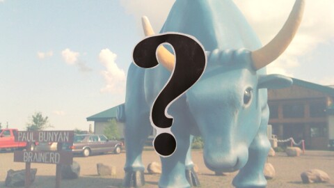 A large blue ox looms in a parking lot near a sign reading "Paul Bunyan, Brainerd"; a question mark in the foreground
