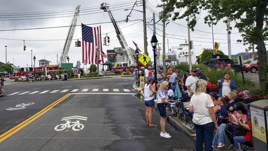 An American flag towers over families who begin to fill the streets of Village of Port Jefferson for the annual Independence Day parade.