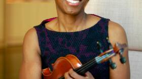 African woman with short hair holding her violin