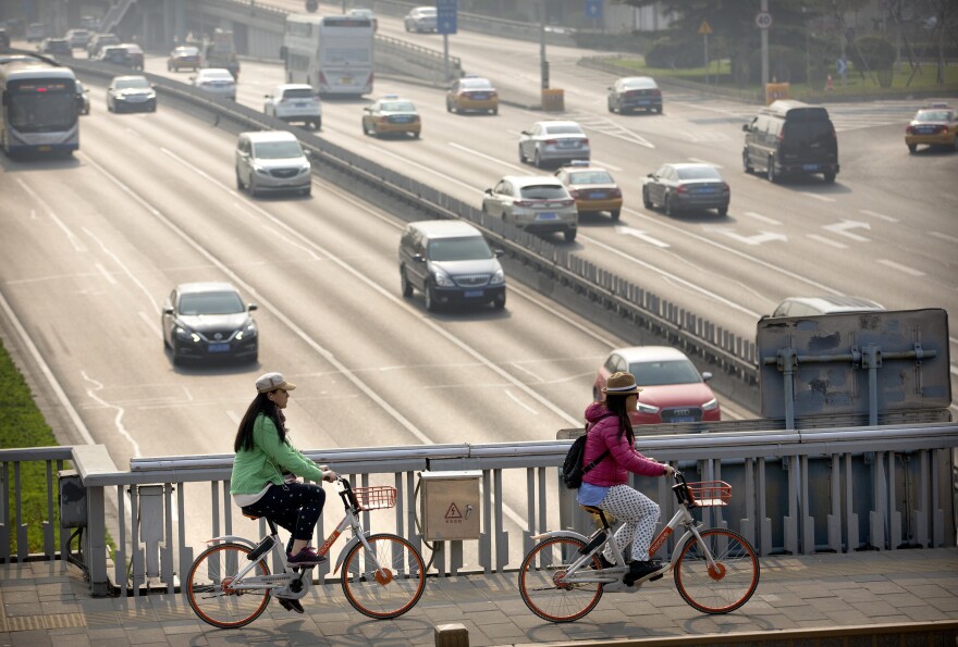 People ride Mobike shared bicycles along an expressway overpass in Beijing.