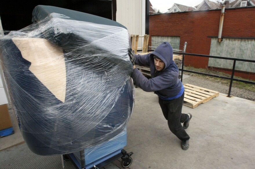 In this photo made on Dec. 18, 2009, Robb Griska pushes a well padded anesthesiology machine destined for Cuba into a truck at the warehouse of Global Links in Pittsburgh.