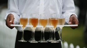 A waiter carries Champagne during the 'Salon Prive' event at Syon Park stately home in 2014 in London, England.