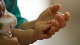 A mother holds her child. I (Rodrigo Buendia/AFP via Getty Images)