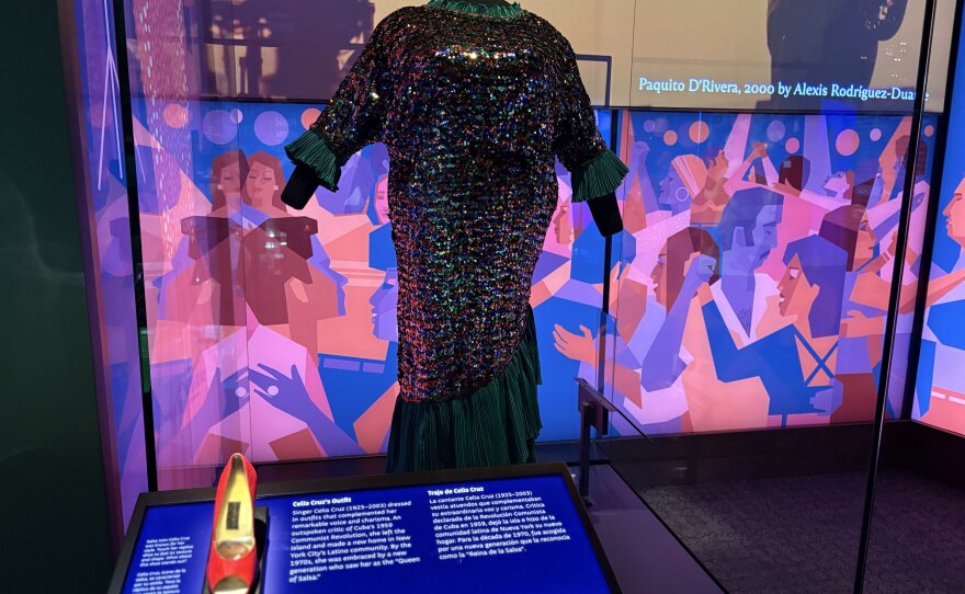 This is one of Celia Cruz’s five dresses that will be on display rotationally during the exhibit’s duration. In front of the dress is a miniature model of Celia’s shoes that visitors can touch.