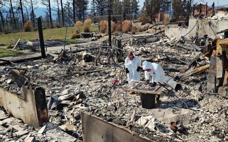 Ryan Herzog sifts through the ashes of his home, which was lost to the recent wildfires in Spokane. (Courtesy of Ryan Herzog)