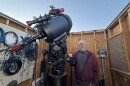 Tom Wildoner stands beside his telescope in his personal observatory.