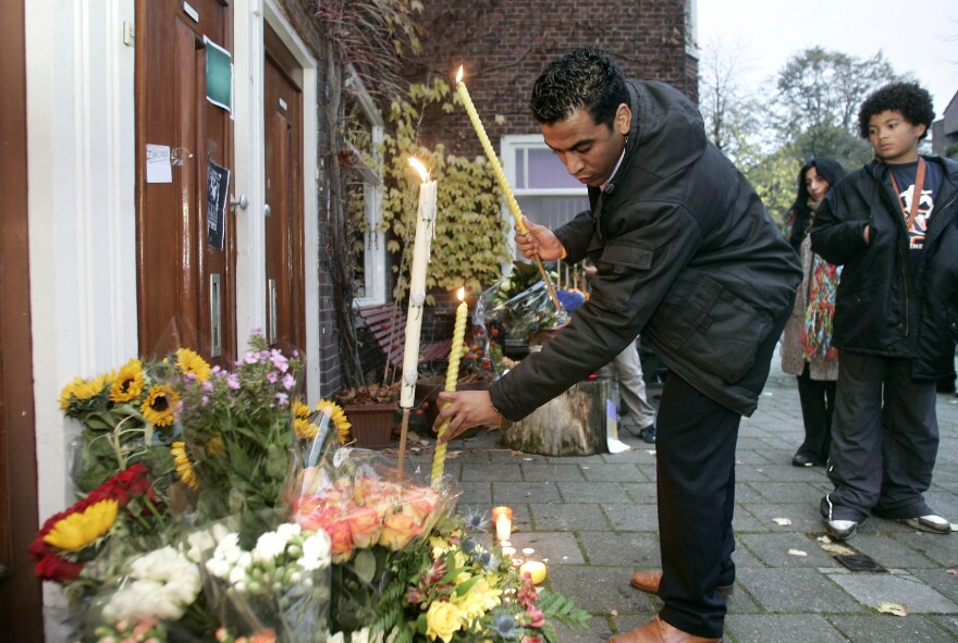 A man places flowers at the home of slain Dutch filmmaker Theo van Gogh in 2004. Van Gogh was killed by a Muslim radical after he made a film criticizing the treatment of women in Islam.