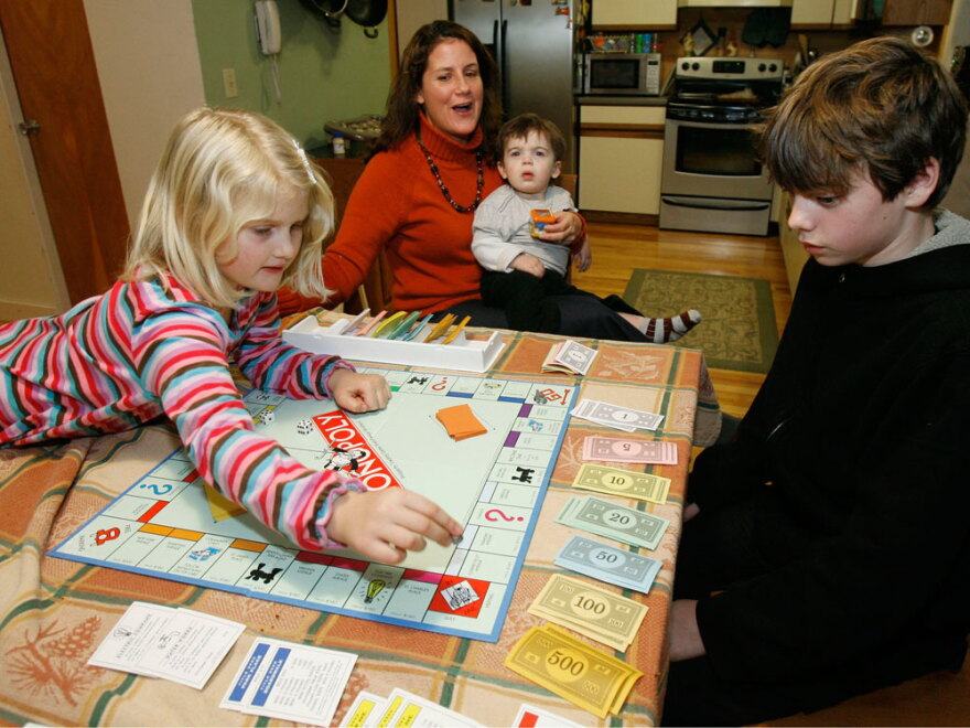 A family plays Monopoly in the kitchen of their home in Jericho, Vt.