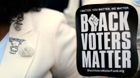 A vote pin is seen on the lapel of Senator Raumesh Akbari, Democrat of Memphis. She holds a sign reading "Black Voters Matter" during a rally after a special session of the state legislature to redraw U.S. Congressional voting maps on Thursday, May 7, 2026, in Nashville, Tennessee. 