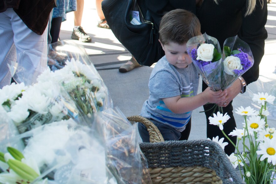 2-year-old Leo Chaney and his mother, Kayla, laid flowers on the steps of Boise City Hall during a vigil for the victims of Saturday night's mass stabbing attack in Boise.