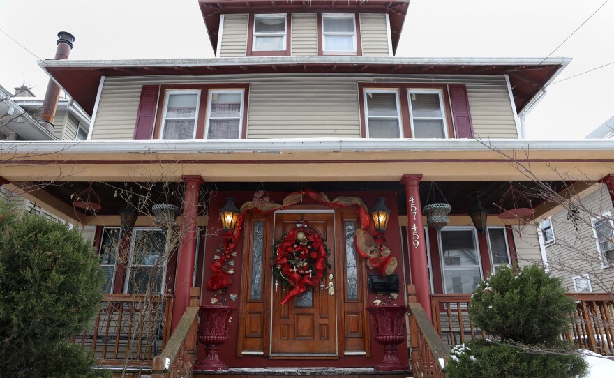 The exterior of a home, decorated for Christmas with ribbons and wreaths