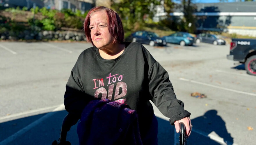 Kim, shown standing outside a Massachusetts shelter motel on Oct. 19, 2026 will soon move to new shelter housing in Lowell. Not having a home, she said, makes you feel "like you're really nobody."