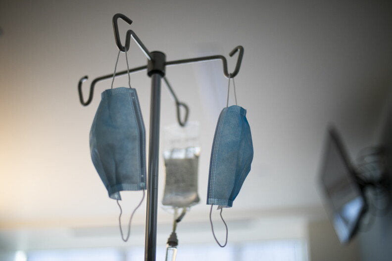Masks hang from an IV pole at a hospital.