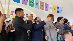 New Hampshire College graduates celebrate by throwing their caps and diplomas in the air. (Carrie Jung/WBUR)