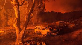 Fire illuminates the remains of a burned-out property near Mariposa, Calif., on Tuesday.