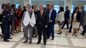 Lawmakers gather for the end of the 2021 legislative session in the state Captiol building holding the symbolic handkerchiefs