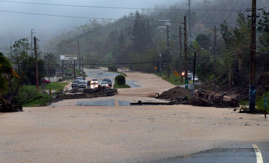 A bridge repair gives out in torrential rain and floodwaters on a street in Utuado.