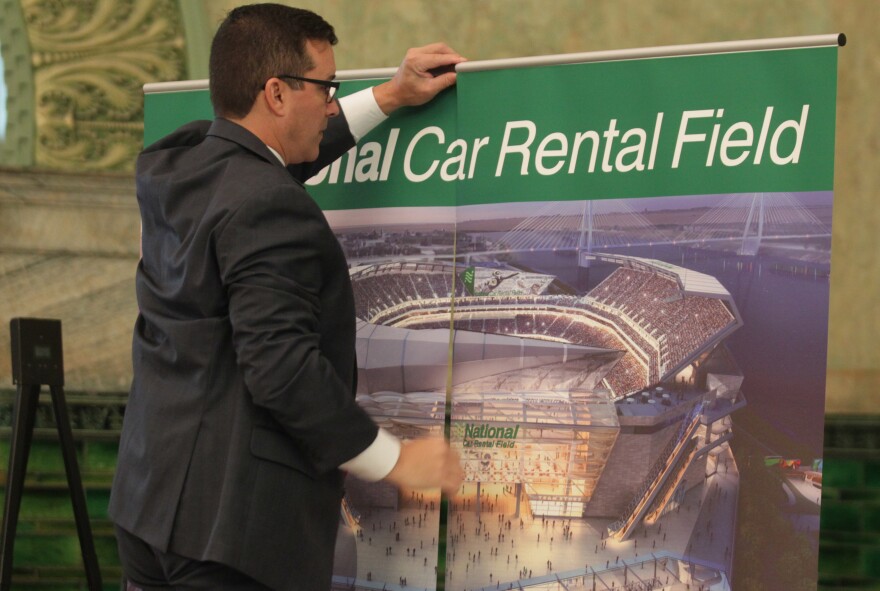 A member of the St. Louis stadium task force places signage in the room before the announcement that National Car Rental has agreed to pay $158 million over 20 years for naming rights for the proposed NFL stadium in St. Louis on October 7, 2015.