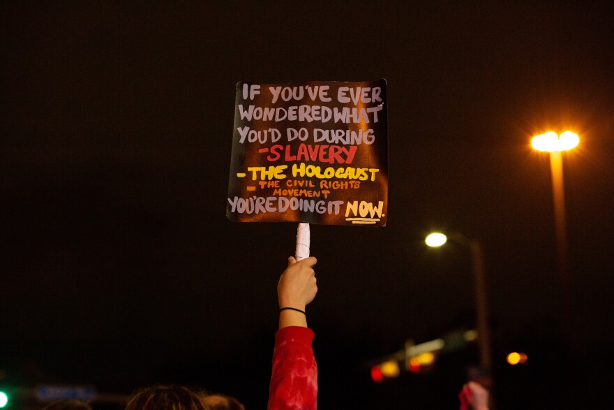 Photo of protester sign that reads "if you ever wondered what you'd do during slavery, the holocaust, the civil rights movement, you're doing it right now."