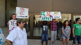 David Lozano watches as speakers talk to crowd of ralliers outside of Dallas City Hall.