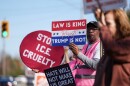 Protesters hold signs during the arrival of federal law enforcement, Wednesday, Nov. 19, 2025, in Charlotte, N.C.