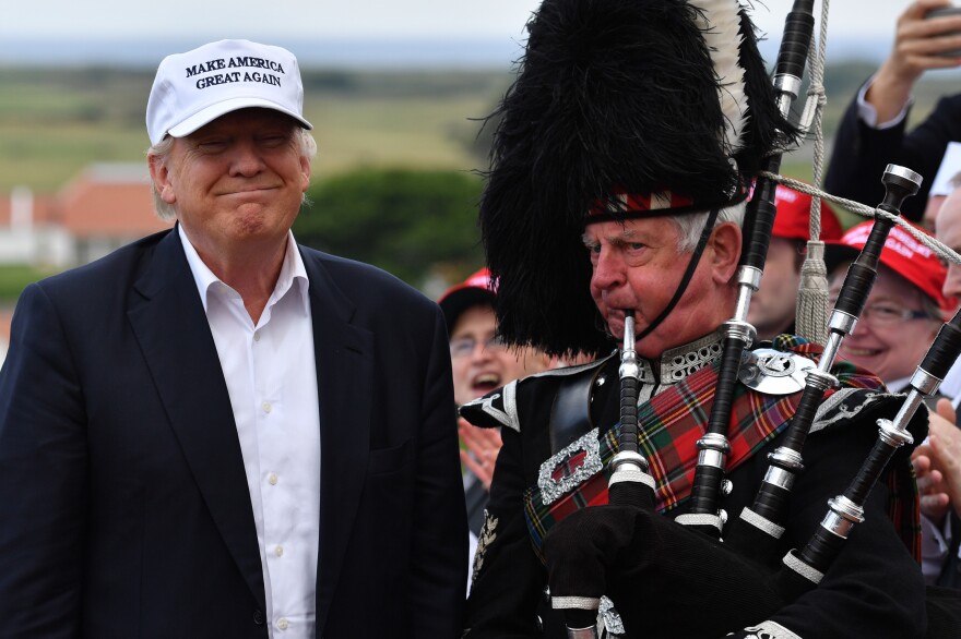 A bagpipe player wears traditional dress next to presumptive Republican presidential nominee Donald Trump at the Trump Turnberry Resort in Ayr, Scotland on Friday.