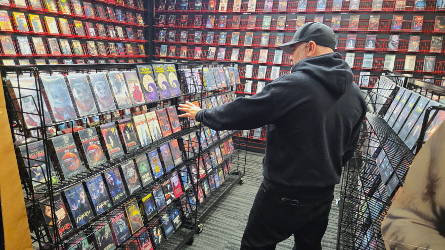 Jonathon Carmichael, owner of Killer Video, points out sections of the museum's immersive exhibit, designed to bring visitors into an old school video rental store filled with classic horror films.