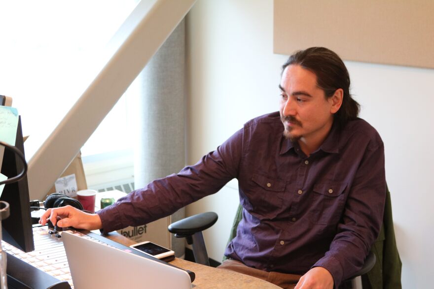 James Dommek Jr is the sole operator for Rising Indigenous Voices Radio, or RIVR. RIVR was launched in September and can be streamed at therivr.net. (Photo by Samantha Davenport, Alaska Public Media)